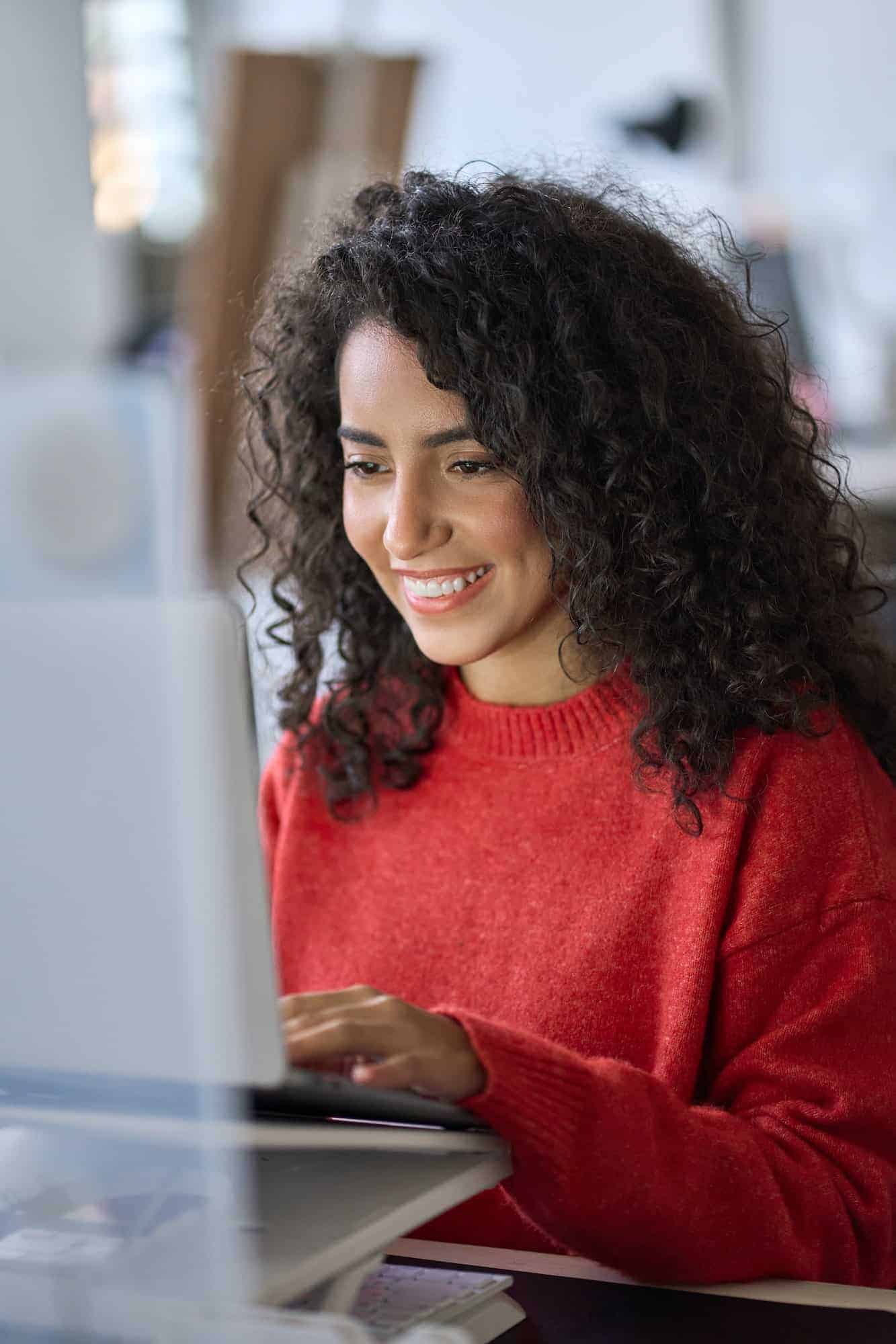 young happy latin woman student elearning using laptop vertical shot | Assessoria Araramax